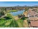 Expansive golf course and serene pond nestled within a friendly neighborhood, all under a bright blue sky at 8243 E Cortez Dr, Scottsdale, AZ 85260