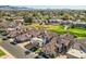 Wide aerial of homes with tile roofs, a green golf course and mountain views at 8243 E Cortez Dr, Scottsdale, AZ 85260