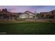 Charming single-story home backyard with lush green lawn and rod iron fence at twilight at 8243 E Cortez Dr, Scottsdale, AZ 85260