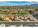 Expansive aerial view of a neighborhood featuring lush greenery, mature trees, and mountain views at 8334 E Jenan Dr, Scottsdale, AZ 85260