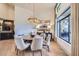 Elegant dining room with contemporary chandelier and large windows at 8334 E Jenan Dr, Scottsdale, AZ 85260