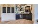 Stylish wet bar area with dark cabinetry, mirrored backsplash, and a wine refrigerator at 8334 E Jenan Dr, Scottsdale, AZ 85260