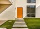 Mid-century modern home with an orange door and a landscaped walkway at 8626 E Mackenzie Dr, Scottsdale, AZ 85251