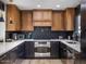 Modern kitchen with wood and dark cabinetry, herringbone backsplash, and stainless steel appliances at 8626 E Mackenzie Dr, Scottsdale, AZ 85251