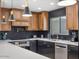 Modern kitchen with dark cabinetry, herringbone backsplash, and stainless steel appliances at 8626 E Mackenzie Dr, Scottsdale, AZ 85251