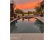 Stunning pool at sunset with a waterfall feature at 9135 E Buckskin Trl, Scottsdale, AZ 85255