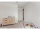 Bright bedroom featuring a dresser, ball pit, and door to hallway at 9354 E Sector Dr, Mesa, AZ 85212