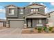 Two-story home with gray siding, stone accents, and a two-car garage at 9354 E Sector Dr, Mesa, AZ 85212