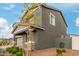 Gray two-story home with stone accents, landscaping, and a two-car garage at 9354 E Sector Dr, Mesa, AZ 85212