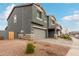 Gray two-story home with stone accents and a two-car garage. Side yard view at 9354 E Sector Dr, Mesa, AZ 85212