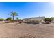 Spacious backyard with gravel landscaping, mature palm trees, and patio area at 9526 W Briarwood N Cir, Sun City, AZ 85351