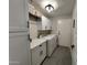 Bright laundry room with white cabinets and a door to outside at 9541 E Fairbrook St, Mesa, AZ 85207