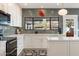 Modern kitchen features white cabinets, marble countertops and a large window at 9915 E Cinnabar Ave, Scottsdale, AZ 85258