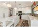 Updated kitchen with white cabinets, marble countertops, and breakfast bar at 9915 E Cinnabar Ave, Scottsdale, AZ 85258