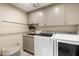 Bright laundry room with shaker cabinets, washer, and dryer at 9915 E Cinnabar Ave, Scottsdale, AZ 85258