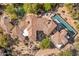 Stunning aerial view of a luxury home with a terracotta roof, long pool, spa and beautifully landscaped desert surroundings at 10420 E Morning Vista Ln, Scottsdale, AZ 85262