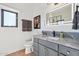 Charming bathroom featuring gray cabinets, stone countertop, and illuminated mirror at 10420 E Morning Vista Ln, Scottsdale, AZ 85262