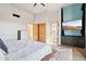 Comfortable bedroom featuring wood floors, multiple closets, and a mounted television at 10420 E Morning Vista Ln, Scottsdale, AZ 85262