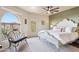 Stylish bedroom with arched window, comfortable seating, and ceiling fan at 10420 E Morning Vista Ln, Scottsdale, AZ 85262