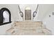Elegant entryway with curved staircase, arched doorway and windows, and tile steps leading to the front door at 10420 E Morning Vista Ln, Scottsdale, AZ 85262