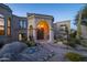 Elegant entryway with arched doorway, columns, and desert landscaping at 10420 E Morning Vista Ln, Scottsdale, AZ 85262
