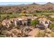 View of large Southwestern home showcasing desert landscaping, tile roof, and neutral-toned exterior at 10420 E Morning Vista Ln, Scottsdale, AZ 85262