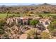 View of large Southwestern home showcasing desert landscaping, tile roof, and neutral-toned exterior at 10420 E Morning Vista Ln, Scottsdale, AZ 85262