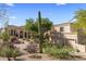 Desert-landscaped exterior with a sprawling home featuring multiple windows and a tile roof at 10420 E Morning Vista Ln, Scottsdale, AZ 85262