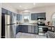 Galley style kitchen features grey cabinetry, stainless steel appliances, and a window with desert views at 10420 E Morning Vista Ln, Scottsdale, AZ 85262
