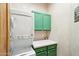 Laundry room with stacked washer and dryer, green cabinets, and counter space for folding at 10420 E Morning Vista Ln, Scottsdale, AZ 85262