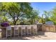 Outdoor kitchen features a built-in grill, bar seating, and desert landscaping at 10420 E Morning Vista Ln, Scottsdale, AZ 85262
