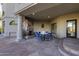Covered patio features a stone fireplace and outdoor dining set at 10420 E Morning Vista Ln, Scottsdale, AZ 85262