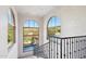 Bright staircase landing featuring large arched windows and wrought iron railing showcasing stunning outdoor views at 10420 E Morning Vista Ln, Scottsdale, AZ 85262