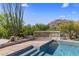 Tranquil swimming pool and stone patio with lush desert landscaping at 10420 E Morning Vista Ln, Scottsdale, AZ 85262