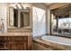 Bright bathroom with a soaking tub and a vanity with granite countertop at 10922 E Purple Aster Way, Scottsdale, AZ 85262