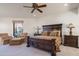 Spacious bedroom with a ceiling fan, seating area, and beautiful furniture at 10922 E Purple Aster Way, Scottsdale, AZ 85262