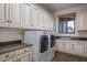 Laundry room with front loading washer and dryer, sink and lots of cabinets at 10922 E Purple Aster Way, Scottsdale, AZ 85262