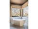 Bright main bath features a modern soaking tub with a large window to enjoy the desert view at 10922 E Purple Aster Way, Scottsdale, AZ 85262