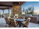 Covered outdoor patio features a dining table, built-in grill, and desert views at 10922 E Purple Aster Way, Scottsdale, AZ 85262