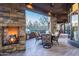 Inviting covered patio with stone fireplace, built-in grill, and comfortable seating area for outdoor living at 10922 E Purple Aster Way, Scottsdale, AZ 85262