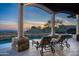Inviting swimming pool framed by stately columns offers stunning desert views at sunset at 10922 E Purple Aster Way, Scottsdale, AZ 85262