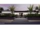 Modern home with a black gated entry, palm trees, and meticulously maintained landscaping at dusk at 11612 N 86Th St, Scottsdale, AZ 85260
