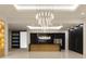 Modern kitchen features sleek black cabinetry, wood island, and striking chandelier lighting at 11612 N 86Th St, Scottsdale, AZ 85260