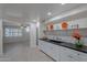 Modern kitchen with white shaker cabinets, black countertops and a farmhouse sink at 12023 N 113Th Ave, Youngtown, AZ 85363