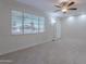 Spacious living room with tile floors, white brick walls and a ceiling fan at 12023 N 113Th Ave, Youngtown, AZ 85363