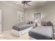 Guest bedroom with twin beds, ceiling fan, and window shutters at 13503 E Summit Dr, Scottsdale, AZ 85259