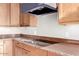 Modern cooktop in a gourmet kitchen with granite countertops and light wood cabinets at 13503 E Summit Dr, Scottsdale, AZ 85259