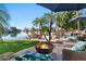 Inviting backyard with a fire pit, pool, and patio furniture, overlooking the lake at 1519 E Treasure Cove Dr, Gilbert, AZ 85234