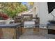 Elegant outdoor kitchen with stainless steel appliances and stone countertops at 1519 E Treasure Cove Dr, Gilbert, AZ 85234