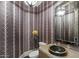 Stylish powder room with unique sink and patterned wallpaper at 1519 E Treasure Cove Dr, Gilbert, AZ 85234